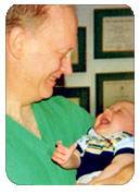 Photo of Dr Stoelk holding a baby